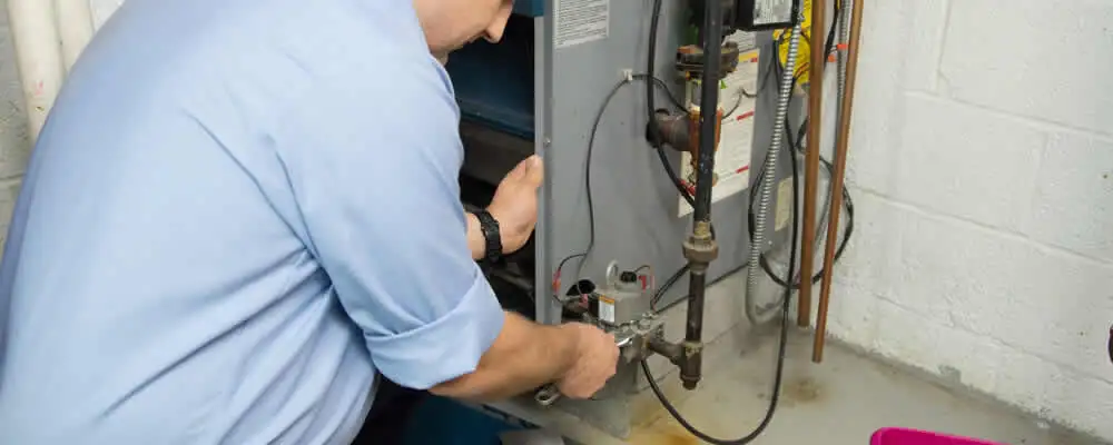 Furnace repair technician inspecting and servicing a home heating system in Long Beach, CA