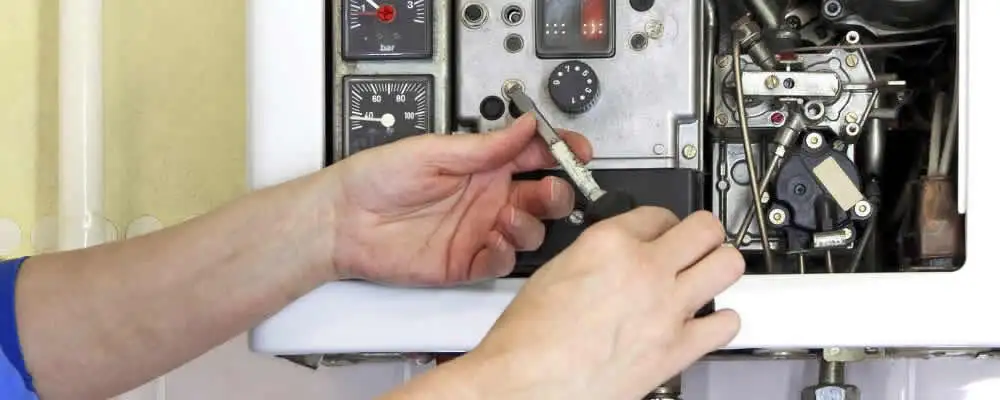 Heating repair technician adjusting boiler controls and components in Long Beach, CA