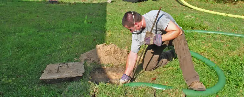 Septic pumping technician servicing a residential septic tank in Long Beach, CA